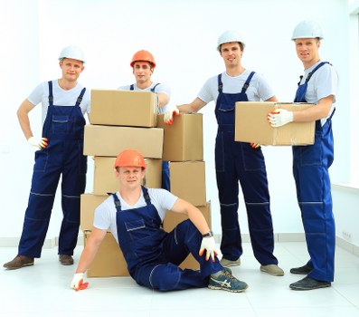 Removal team carrying furniture during flat removals in Acton